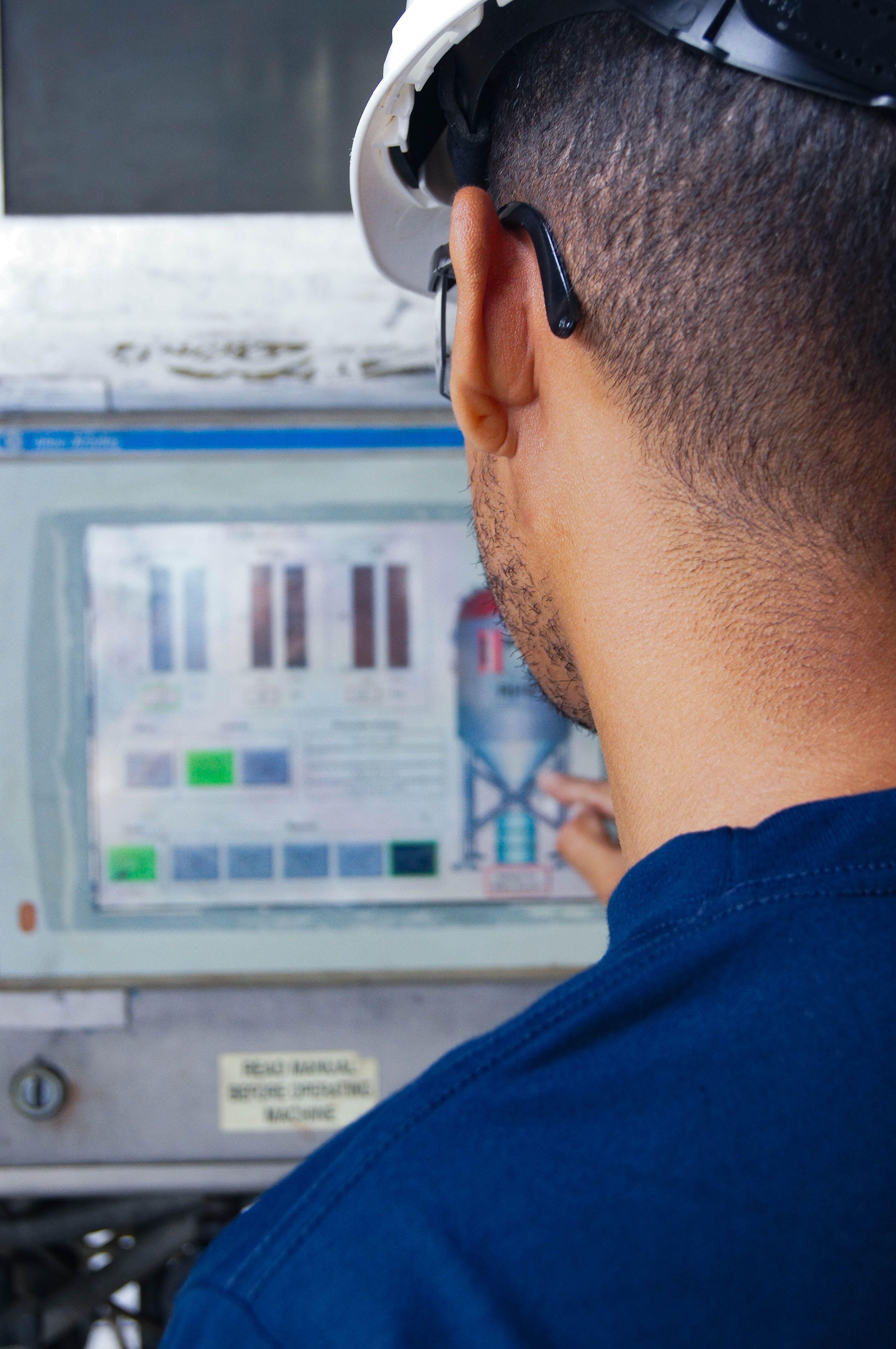 En ingenjör som övervakar en industriell kontrollpanel med realtidsdata